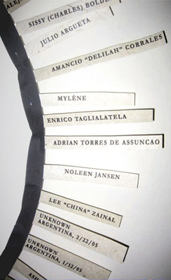 A short section of ribbon with the names of ten trans victims attached
